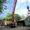 crane-lifting-genset-kontainer-area-sempit-jakarta-asanindo Mobile crane PT Asanindo beroperasi di area sempit perkotaan Jakarta — lifting di lokasi dengan akses terbatas di antara bangunan dan pepohonan