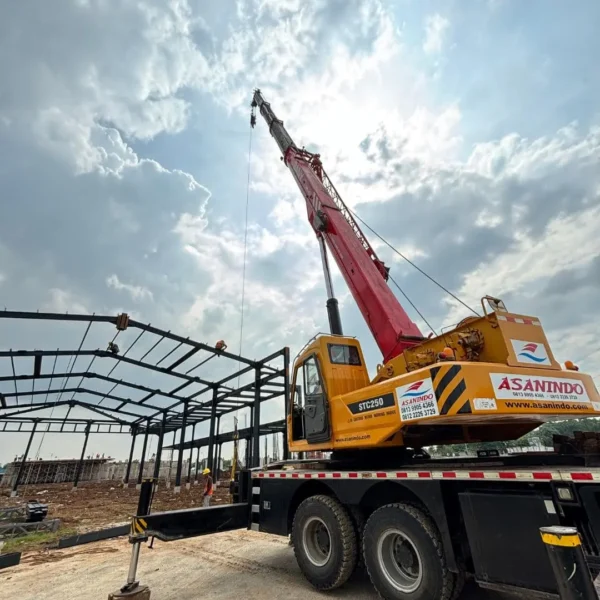 crane-sany-stc250-pemasangan-rangka-baja-gudang-jakarta-asanindo Mobile crane SANY STC250 milik PT Asanindo sedang mengangkat struktur baja untuk proyek konstruksi gedung di Jakarta